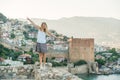 Young blond woman tourist balancing on ancient fortress wall of Alanya castle. Royalty Free Stock Photo