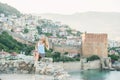 Young blond woman tourist sitting on ancient fortress wall of Alanya castle. Royalty Free Stock Photo