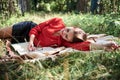 Young blond woman, wearing red shirt, lying sleeping on brown blanket. Creative close-up portrait, with person surrounded with Royalty Free Stock Photo