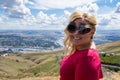 Young blonde adult woman poses at the Lewiston Idaho Hill Overlook into the Clearwater Valley, wearing novelty pineapple