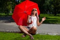 Young Blonde Athletic woman holding a Red Umbrella