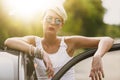 Young blonde attractive woman is ready to enter in her car. She is opening the door and staying behind it Royalty Free Stock Photo