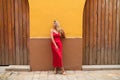 Young, blonde, beautiful woman in a red dress is visiting seville. The woman is posing for the camera very elegant for the photos Royalty Free Stock Photo