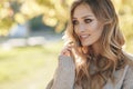 Young blonde beautiful woman spends time alone on a sunny day in a city park Royalty Free Stock Photo