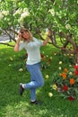 Young blonde with a big breast is standing in the park under a flowering tree Royalty Free Stock Photo