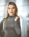 Young blonde business woman or female student standing straight and posing at camera in sunny office Royalty Free Stock Photo