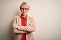 Young blonde business woman with short hair wearing glasses and elegant jacket skeptic and nervous, disapproving expression on Royalty Free Stock Photo