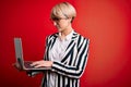 Young blonde business woman with short hair wearing glasses working using computer laptop with a confident expression on smart Royalty Free Stock Photo