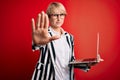 Young blonde business woman with short hair wearing glasses working using computer laptop with open hand doing stop sign with Royalty Free Stock Photo