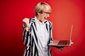 Young blonde business woman with short hair wearing glasses working using computer laptop screaming proud and celebrating victory Royalty Free Stock Photo