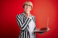 Young blonde business woman with short hair wearing glasses working using computer laptop serious face thinking about question, Royalty Free Stock Photo