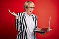 Young blonde business woman with short hair wearing glasses working using computer laptop very happy and excited, winner Royalty Free Stock Photo