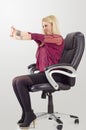 Young blonde businesswoman doing stretching, while sitting in chair