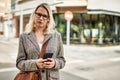 Young blonde businesswoman with serious expression using smartphone at the city Royalty Free Stock Photo