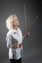 Young blonde caucasian girl violinist posing holding two violin bows