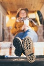 Young blonde Caucasian woman relaxing in her campervan at sunset