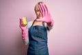 Young blonde cleaner woman with short hair wearing apron and gloves holding scrub scourer with open hand doing stop sign with