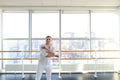 Young blonde dancer enjoys winning in white suit and makes warm Royalty Free Stock Photo