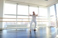 Young blonde dancer enjoys winning in white suit and makes warm Royalty Free Stock Photo