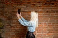 Young blonde do selfie. Selfshot outdoors against red brick wall Royalty Free Stock Photo