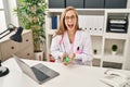 Young blonde doctor woman holding pills winking looking at the camera with sexy expression, cheerful and happy face Royalty Free Stock Photo