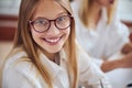 Young blonde female child with cute smile choosing best eyeglass in office ophthalmologist Royalty Free Stock Photo