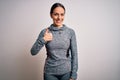 Young blonde fitness woman wearing sport workout clothes over isolated background doing happy thumbs up gesture with hand Royalty Free Stock Photo