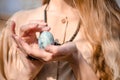 Young blonde girl in boho style dress, near tree with blue egg like dragon egg, photo for cover of book, movie or album