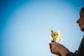 Young blonde girl in dress with shoulder bag, walking on dandelion field Royalty Free Stock Photo