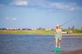 Young blonde girl fishing on boat in lake