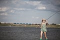 Young blonde girl fishing in lake Royalty Free Stock Photo