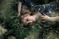 Young blonde girl with long hair lying in the grass.