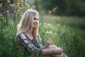 Young blonde girl with long hair lying in the grass.