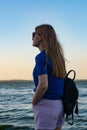 Young blonde girl looking sea and blue skies back view Royalty Free Stock Photo