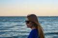 Young blonde girl looking sea and blue skies back view Royalty Free Stock Photo