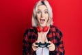 Young blonde girl playing video game holding controller celebrating crazy and amazed for success with open eyes screaming excited Royalty Free Stock Photo