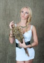 Young blonde girl posing in Slavic ethnic decorations and with a bouquet of dried gilded flowers