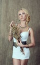 Young blonde girl posing in Slavic ethnic decorations and with a bouquet of dried gilded flowers