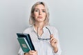 Young blonde girl reading a book and holding glasses depressed and worry for distress, crying angry and afraid Royalty Free Stock Photo