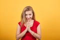 Young blonde girl in red t-shirt over isolated orange background shows emotions Royalty Free Stock Photo