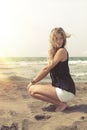 Young blonde hair girl relaxing on the beach sand. Wind in her blond hair Royalty Free Stock Photo