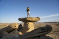 Young blonde girl in shorts on top of the cliff in a desert in Las Bardenas Reales, Navarra, Spain