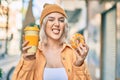 Young blonde girl smiling happy having breakfast at the city