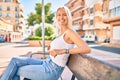 Young blonde girl smiling happy sitting on the bench at the park Royalty Free Stock Photo