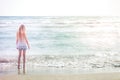 Young blonde girl standing on the beach Royalty Free Stock Photo