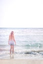 Young blonde girl standing on the beach Royalty Free Stock Photo