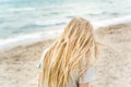 Young blonde girl standing on the beach Royalty Free Stock Photo