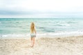 Young blonde girl standing on the beach Royalty Free Stock Photo