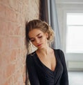 A young blonde girl in a strict, discreet, modest, elegant, long black dress. Delicate natural make-up. Beautiful Royalty Free Stock Photo