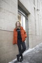 Young blonde girl in stylish orange jacket